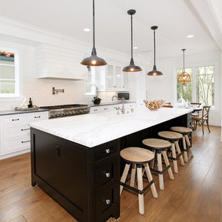 Ejemplo de cocina de galera, tradicional, abierta, con armarios con paneles empotrados, puertas de armario blancas, encimera de mármol, salpicadero blanco y salpicadero de azulejos tipo metro