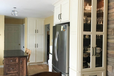 Mid-sized transitional galley light wood floor and beige floor eat-in kitchen photo in Other with an undermount sink, shaker cabinets, white cabinets, quartz countertops, an island, black countertops and stainless steel appliances