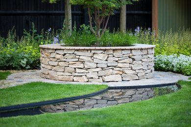 Design ideas for a contemporary back garden in London with natural stone paving.