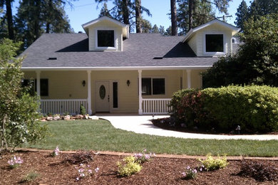 Example of a classic yellow two-story concrete fiberboard exterior home design in Other with a gray roof