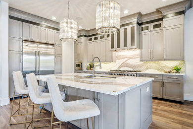 Eat-in kitchen - large contemporary l-shaped light wood floor and brown floor eat-in kitchen idea in New York with a drop-in sink, dark wood cabinets, granite countertops, white backsplash, glass tile backsplash, stainless steel appliances, an island and white countertops