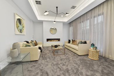 Photo of a large traditional formal enclosed living room in Melbourne with grey walls, carpet, a ribbon fireplace, a plaster fireplace surround and grey floor.