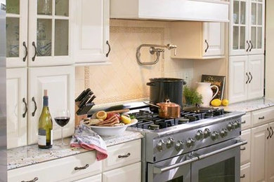 Example of a mid-sized transitional galley dark wood floor kitchen design in New York with raised-panel cabinets, white cabinets, quartz countertops, beige backsplash, terra-cotta backsplash and stainless steel appliances