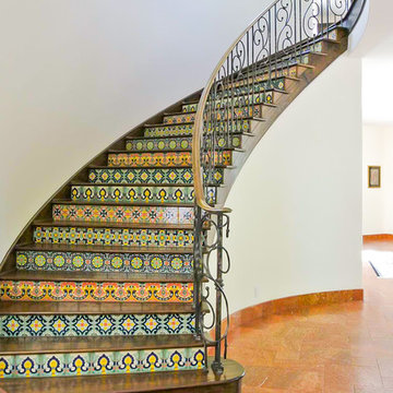 Curving Staircase with Tiled Risers and Wrought Iron Handrails.