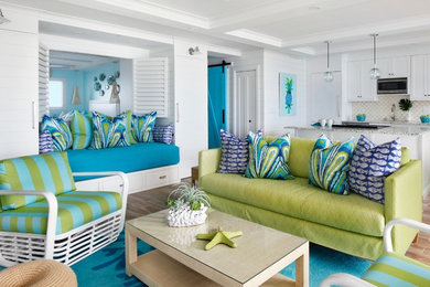 Photo of a beach style open concept living room in Hawaii with white walls, medium hardwood floors and brown floor.