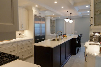 Eat-in kitchen - large transitional u-shaped beige floor eat-in kitchen idea in Toronto with a double-bowl sink, recessed-panel cabinets, white cabinets, quartzite countertops, white backsplash, stainless steel appliances and an island