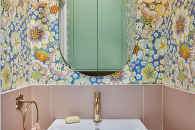 Photo of a small bohemian cloakroom in London with pink tiles, porcelain tiles, a floating vanity unit and wallpapered walls.