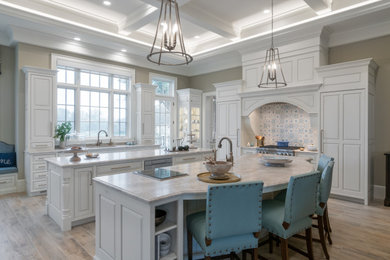 Example of a huge classic eat-in kitchen design in Grand Rapids with beaded inset cabinets, white cabinets, quartzite countertops, blue backsplash, stainless steel appliances, two islands and beige countertops