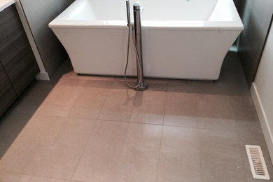 Freestanding bathtub - modern gray tile and ceramic tile porcelain tile and beige floor freestanding bathtub idea in Calgary with flat-panel cabinets, dark wood cabinets, white walls and quartz countertops