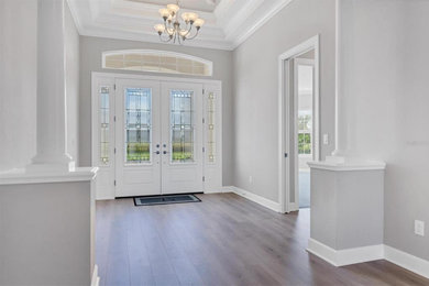 Large transitional laminate floor, multicolored floor and coffered ceiling double front door photo in Other with gray walls and a white front door