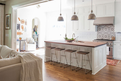 Inspiration for a mid-sized transitional l-shaped dark wood floor and brown floor open concept kitchen remodel in Charlotte with an undermount sink, white cabinets, wood countertops, stainless steel appliances, an island, recessed-panel cabinets and multicolored backsplash
