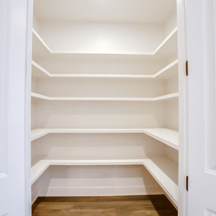 Mittelgroße Klassische Küche in U-Form mit Vorratsschrank, Unterbauwaschbecken, Schrankfronten im Shaker-Stil, weißen Schränken, Granit-Arbeitsplatte, Küchenrückwand in Weiß, Rückwand aus Metrofliesen, Küchengeräten aus Edelstahl, dunklem Holzboden, Kücheninsel, braunem Boden und bunter Arbeitsplatte in Austin