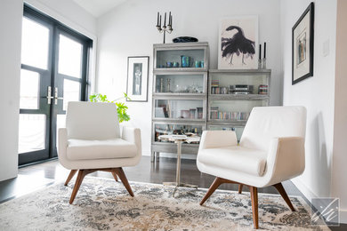 Example of a mid-sized minimalist formal and open concept dark wood floor and black floor living room design in Toronto with white walls, a standard fireplace, a plaster fireplace and no tv