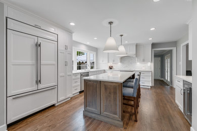 Enclosed kitchen - mid-sized traditional u-shaped light wood floor enclosed kitchen idea in DC Metro with an undermount sink, white cabinets, gray backsplash, ceramic backsplash, stainless steel appliances, an island and white countertops