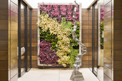 Photo of a small beach style courtyard full sun garden in Los Angeles with a vertical garden and natural stone pavers.