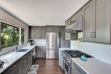 Inspiration for a large mid-century modern galley dark wood floor and brown floor eat-in kitchen remodel in Seattle with an undermount sink, shaker cabinets, gray cabinets, quartz countertops, white backsplash, ceramic backsplash, stainless steel appliances, no island and white countertops