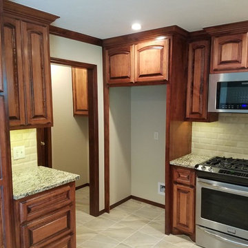 Cabinet above refrigerator has dividers for cutting boards and cookie sheets