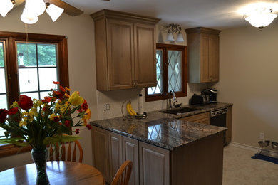 Inspiration for a small contemporary l-shaped kitchen pantry remodel in Chicago with an undermount sink, raised-panel cabinets, beige cabinets, quartz countertops, white backsplash, glass tile backsplash, stainless steel appliances and no island