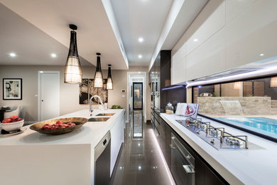 Inspiration for a large contemporary eat-in kitchen in Canberra - Queanbeyan with quartz benchtops, porcelain floors, with island, a double-bowl sink, flat-panel cabinets, dark wood cabinets, stainless steel appliances and window splashback.