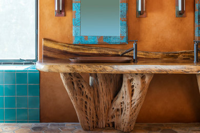 Photo of a bathroom in Los Angeles with light wood cabinets, a freestanding tub, blue tile, ceramic tile, concrete floors, a drop-in sink, wood benchtops, multi-coloured floor, a hinged shower door and brown benchtops.