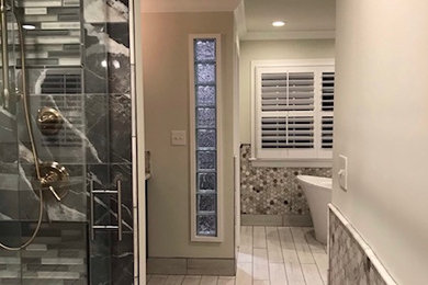Modelo de cuarto de baño principal, flotante y doble actual con puertas de armario negras, encimera de granito, encimeras grises y lavabo bajoencimera