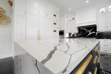 Eat-in kitchen - huge scandinavian u-shaped ceramic tile and black floor eat-in kitchen idea in Toronto with an undermount sink, shaker cabinets, white cabinets, quartz countertops, black backsplash, quartz backsplash, white appliances, an island and black countertops