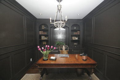 Example of a mid-sized classic freestanding desk dark wood floor study room design in Toronto with black walls
