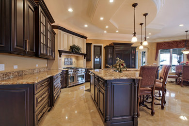 Kitchen - mediterranean u-shaped marble floor kitchen idea in Chicago with stainless steel appliances, an undermount sink, raised-panel cabinets, dark wood cabinets, granite countertops, beige backsplash, porcelain backsplash and an island