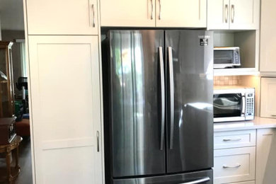 Inspiration for a mid-sized transitional l-shaped vinyl floor and multicolored floor enclosed kitchen remodel in Other with a double-bowl sink, shaker cabinets, beige cabinets, quartz countertops, beige backsplash, ceramic backsplash, stainless steel appliances and beige countertops