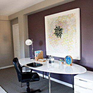 This is an example of a large modern study in Los Angeles with purple walls, carpet, no fireplace, a freestanding desk and grey floors.
