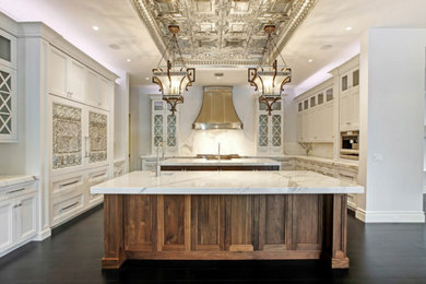 Enclosed kitchen - large mediterranean u-shaped dark wood floor enclosed kitchen idea in Miami with an undermount sink, recessed-panel cabinets, white cabinets, marble countertops, white backsplash, stone slab backsplash, paneled appliances and an island