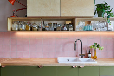 Foto de cocina minimalista de tamaño medio con armarios con paneles lisos, puertas de armario verdes y encimera de madera