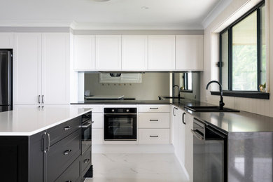 Modern kitchen in Newcastle - Maitland with mirror splashback and an island.