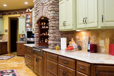 Example of a large mountain style u-shaped porcelain tile and beige floor eat-in kitchen design in Other with an undermount sink, raised-panel cabinets, green cabinets, granite countertops, beige backsplash, porcelain backsplash, stainless steel appliances, an island and multicolored countertops