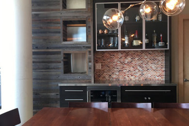 Example of a mid-sized trendy wet bar design in Minneapolis with glass-front cabinets, black cabinets, stainless steel countertops and multicolored backsplash