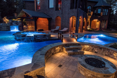 Modelo de piscina natural clásica grande a medida en patio trasero con paisajismo de piscina