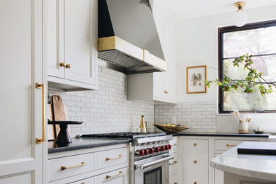 Example of a classic l-shaped eat-in kitchen design in Grand Rapids with shaker cabinets, white cabinets, quartzite countertops and an island