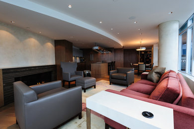 Inspiration for a large contemporary open concept medium tone wood floor living room remodel in Vancouver with multicolored walls, a standard fireplace, a stone fireplace and no tv