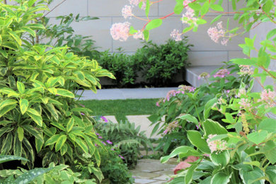 Inspiration for a small modern side yard garden in Other with natural stone pavers.