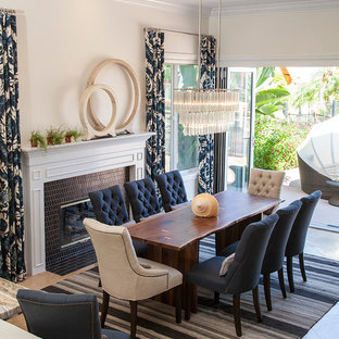 Idées déco pour une grande salle à manger ouverte sur la cuisine classique avec un mur gris, un sol en calcaire et un manteau de cheminée en carrelage.