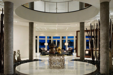 Huge minimalist porcelain tile and white floor entryway photo in Miami with beige walls