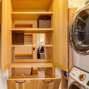 Inspiration for a small classic l-shaped utility room in Denver with open cabinets and a stacked washer and dryer.