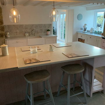 Beautiful pale pink, country kitchen with large island and full length larders