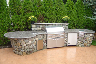 Example of a mid-sized transitional backyard brick patio kitchen design in New York with no cover