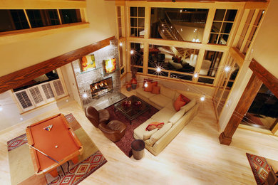 Game room - large rustic open concept light wood floor and brown floor game room idea in Denver with beige walls, a standard fireplace, a stone fireplace and no tv