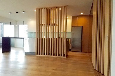 Small minimalist l-shaped light wood floor and beige floor open concept kitchen photo in San Francisco with flat-panel cabinets, medium tone wood cabinets, glass sheet backsplash, stainless steel appliances and an island