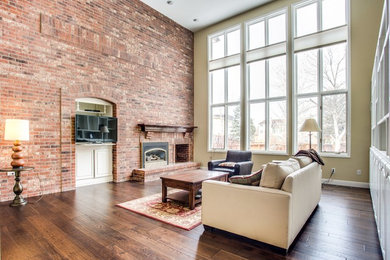 Family room - large transitional open concept dark wood floor and brown floor family room idea in Denver with multicolored walls, a brick fireplace, a standard fireplace and a wall-mounted tv