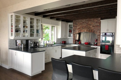 Inspiration for a contemporary u-shaped dark wood floor and brown floor eat-in kitchen remodel in Seattle with an undermount sink, shaker cabinets, white cabinets, soapstone countertops, white backsplash, subway tile backsplash, stainless steel appliances, an island and gray countertops