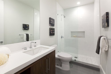 Design ideas for a mid-sized transitional kids bathroom in San Francisco with a one-piece toilet, white tile, subway tile, white walls, flat-panel cabinets, dark wood cabinets, an alcove shower, ceramic floors, an undermount sink and engineered quartz benchtops.