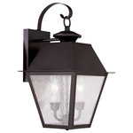 Livex Lighting - Mansfield Outdoor Wall Lantern, Bronze - Illuminate a driveway or terrace area with the Mansfield Wall Lantern. Modeled on traditional, Victorian-style lamps, it features a bronze shade with seeded glass panels suspended from a curved mount. The lantern is weatherproof and makes an elegant addition to an exterior wall or porch.